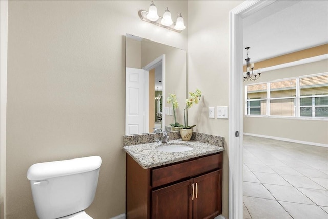 bathroom with tile patterned flooring, vanity, a notable chandelier, and toilet