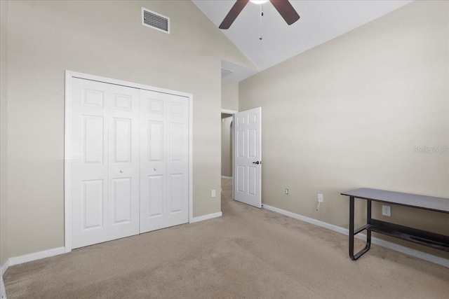 bedroom with ceiling fan, a closet, high vaulted ceiling, and light carpet