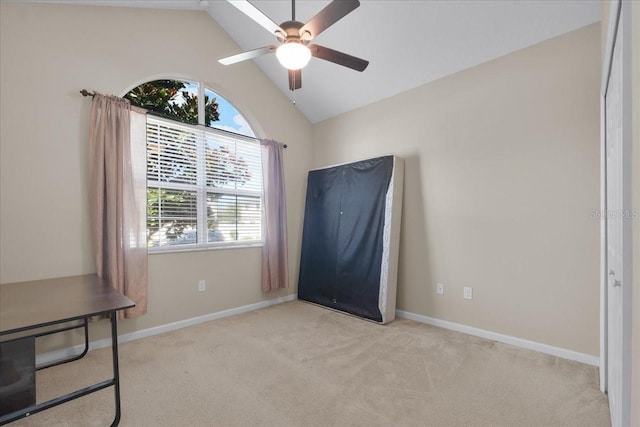 interior space featuring vaulted ceiling, light colored carpet, and ceiling fan