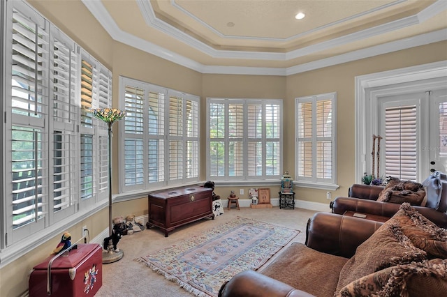 carpeted living room featuring crown molding, a healthy amount of sunlight, and a tray ceiling