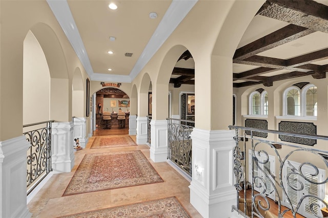 hall with visible vents, beamed ceiling, a wainscoted wall, recessed lighting, and a decorative wall