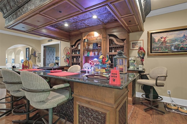 office area with coffered ceiling, crown molding, light hardwood / wood-style flooring, and bar area