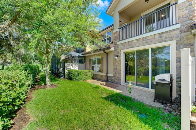 back of house with a lawn and a balcony