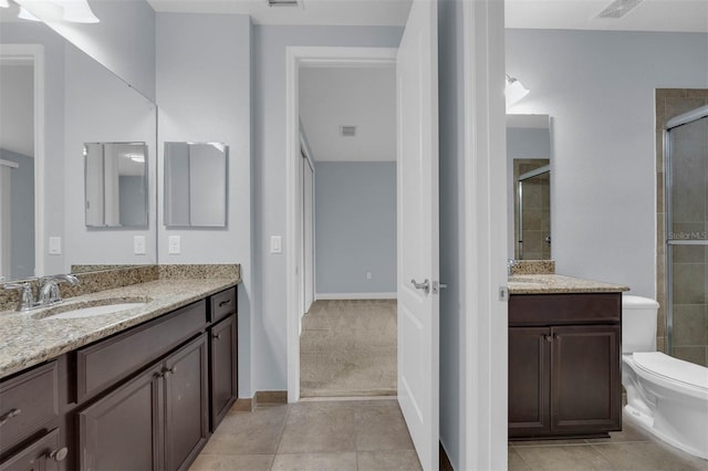 bathroom with tile patterned flooring, vanity, walk in shower, and toilet