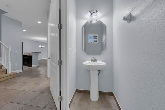 bathroom featuring tile patterned flooring, vaulted ceiling, and sink