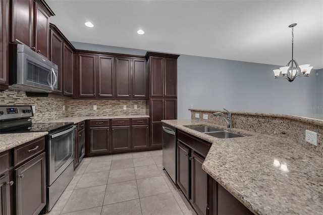 kitchen featuring sink, hanging light fixtures, light tile patterned floors, appliances with stainless steel finishes, and light stone countertops