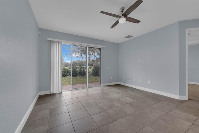 tiled empty room featuring ceiling fan