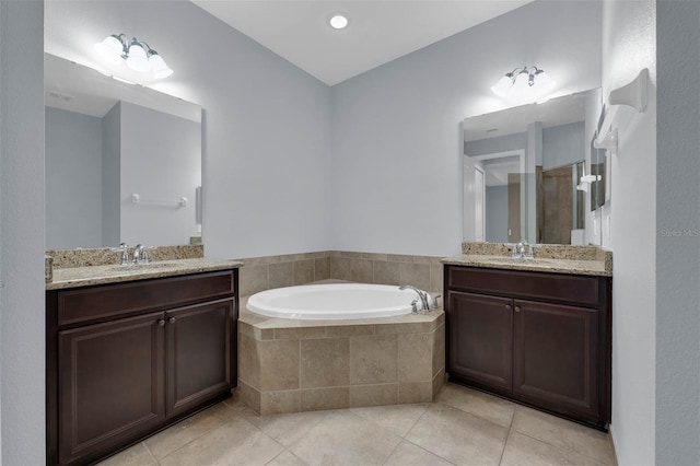 bathroom with vanity, tiled bath, and tile patterned floors