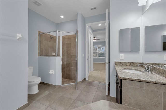 bathroom with tile patterned flooring, vanity, walk in shower, and toilet