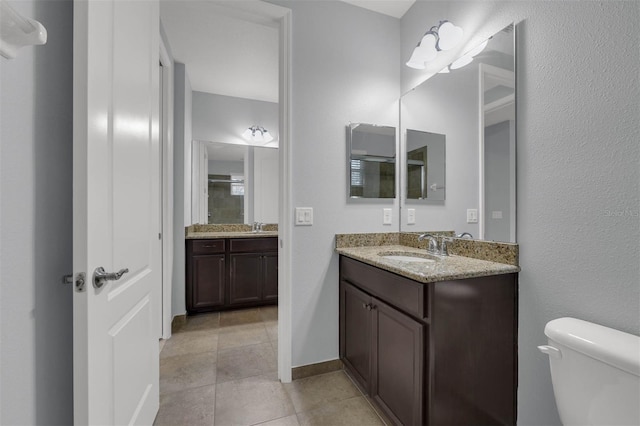 bathroom featuring vanity, tile patterned floors, and toilet