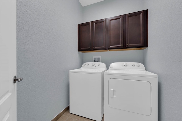 laundry room with cabinets, washer and dryer, and light tile patterned floors