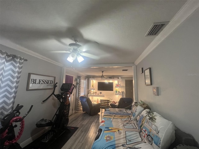 bedroom featuring wood-type flooring, ornamental molding, ceiling fan, and a textured ceiling