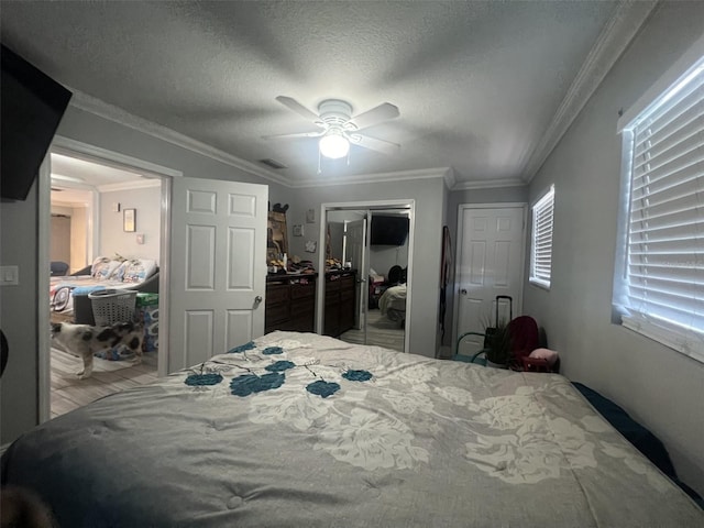 bedroom featuring light hardwood / wood-style floors, a textured ceiling, ceiling fan, and crown molding