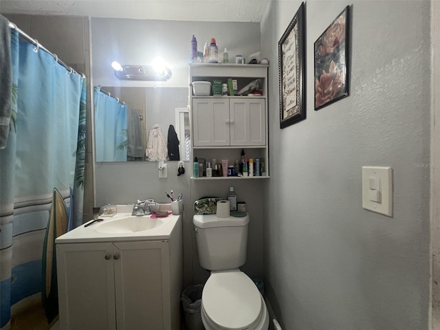 bathroom featuring a shower with curtain, vanity, and toilet