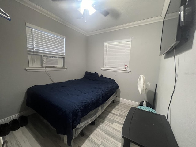 bedroom featuring cooling unit, ornamental molding, light wood-type flooring, and ceiling fan