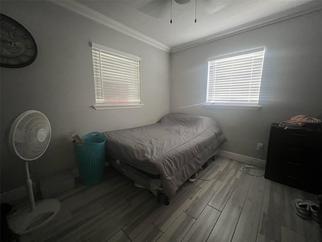 bedroom featuring wood-type flooring, ceiling fan, and crown molding