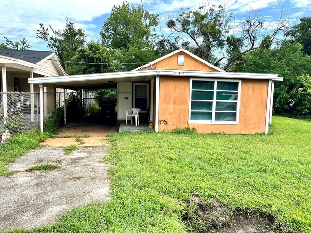 bungalow-style house featuring a carport and a front lawn