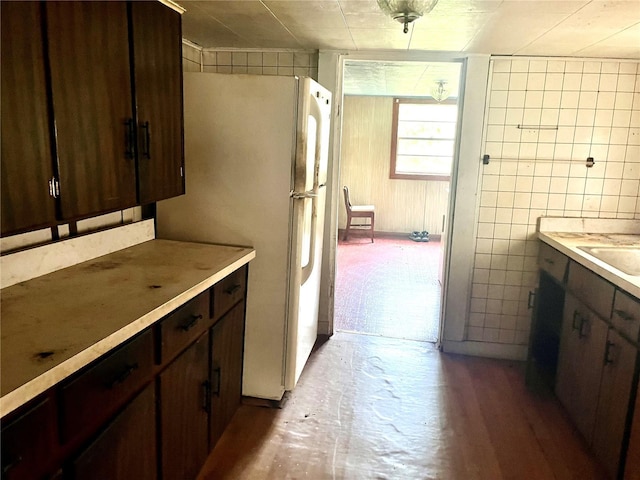 kitchen with white fridge and dark brown cabinetry