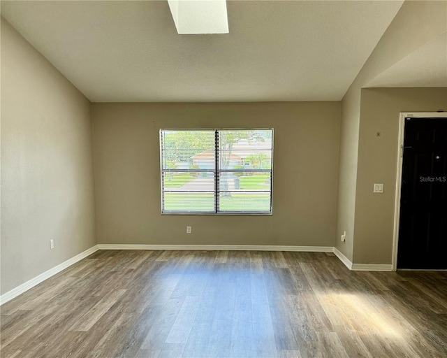 empty room with baseboards and wood finished floors