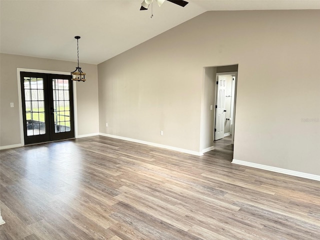 empty room featuring wood-type flooring, french doors, high vaulted ceiling, and ceiling fan