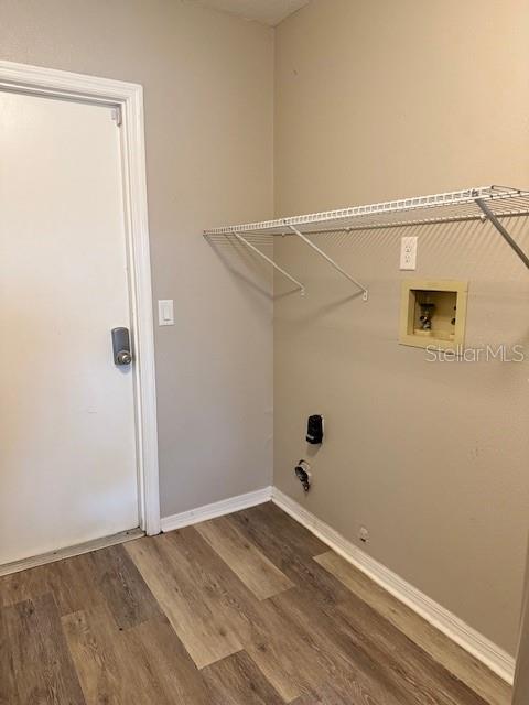 laundry area featuring hookup for a washing machine, gas dryer hookup, wood finished floors, laundry area, and baseboards