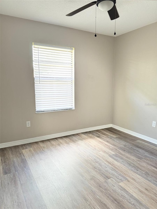 empty room with ceiling fan and hardwood / wood-style flooring