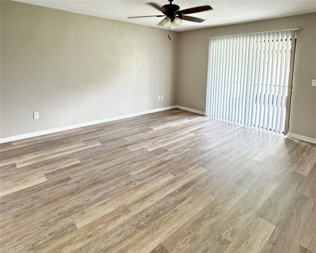 empty room featuring a textured ceiling, hardwood / wood-style floors, and ceiling fan