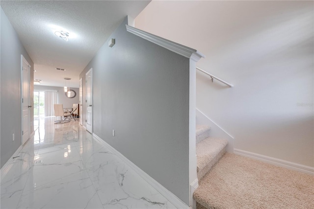 stairway featuring a textured ceiling and tile patterned flooring