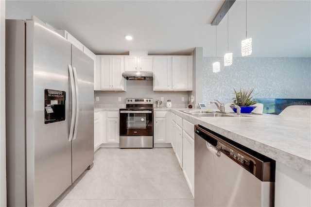 kitchen featuring white cabinetry, light tile patterned floors, stainless steel appliances, hanging light fixtures, and sink