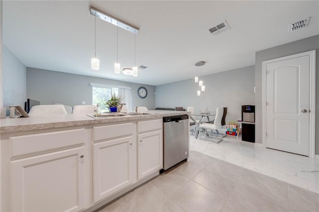 kitchen with white cabinets, pendant lighting, light tile patterned floors, and stainless steel dishwasher