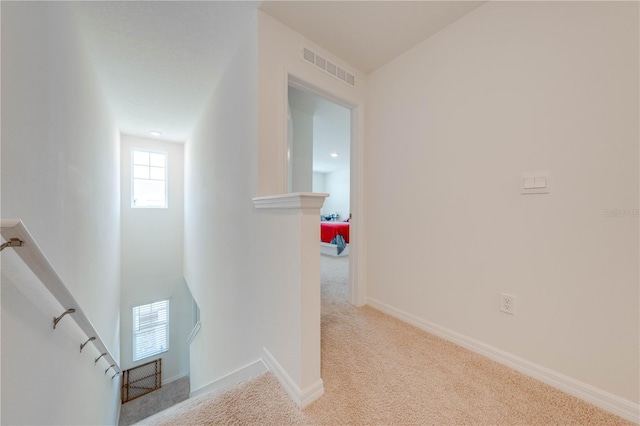 hallway featuring light colored carpet