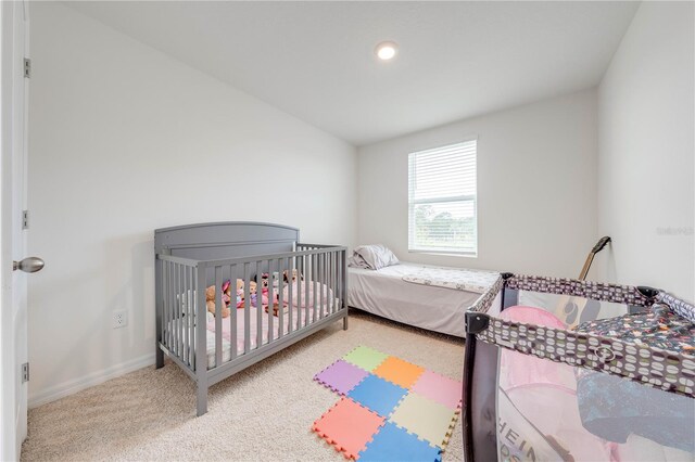 bedroom with vaulted ceiling and light colored carpet