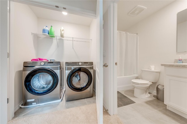 washroom with light tile patterned flooring and washing machine and dryer