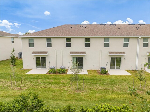 rear view of property with a patio and a lawn