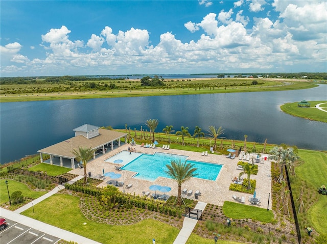 view of pool featuring a water view and a yard