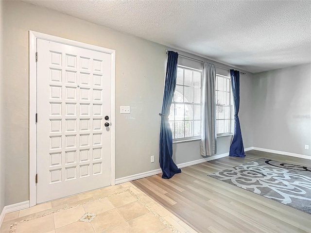 entrance foyer with light hardwood / wood-style flooring and a textured ceiling