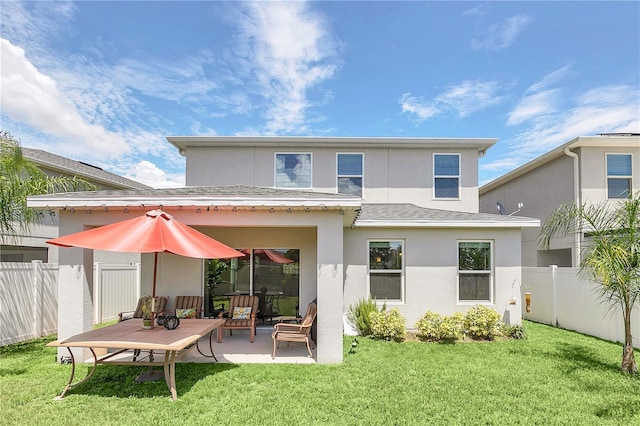 rear view of house with a lawn and a patio area