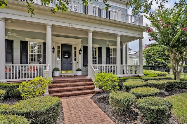 property entrance featuring ceiling fan, a balcony, and a porch