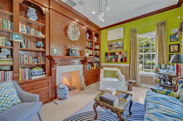 sitting room with a premium fireplace, crown molding, wooden walls, and built in shelves