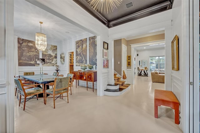 dining space featuring crown molding and a chandelier