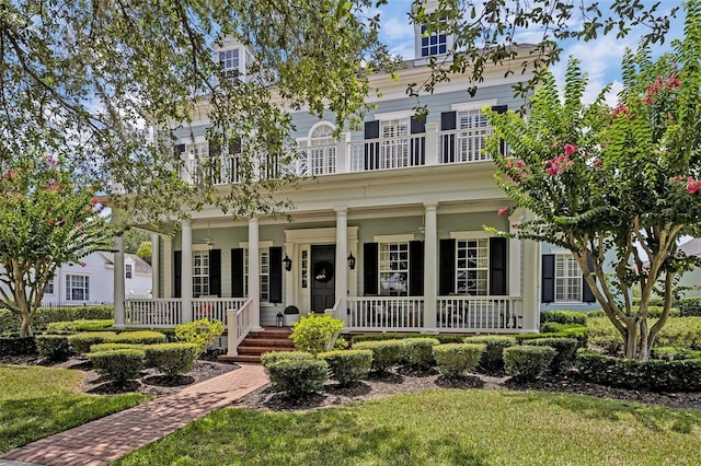 view of front of property featuring a porch, a balcony, and a front lawn