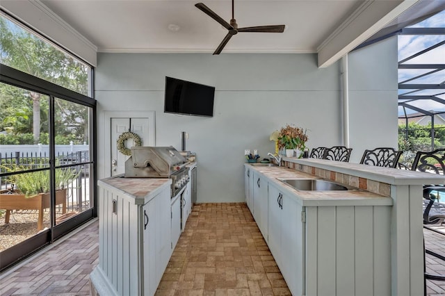 kitchen with sink, a breakfast bar area, kitchen peninsula, ceiling fan, and white cabinets