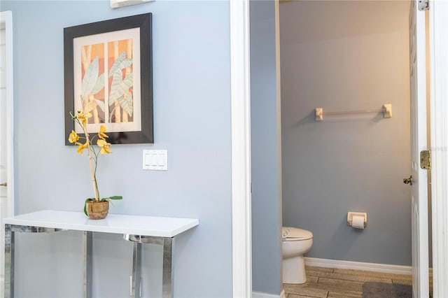 bathroom with toilet and hardwood / wood-style flooring