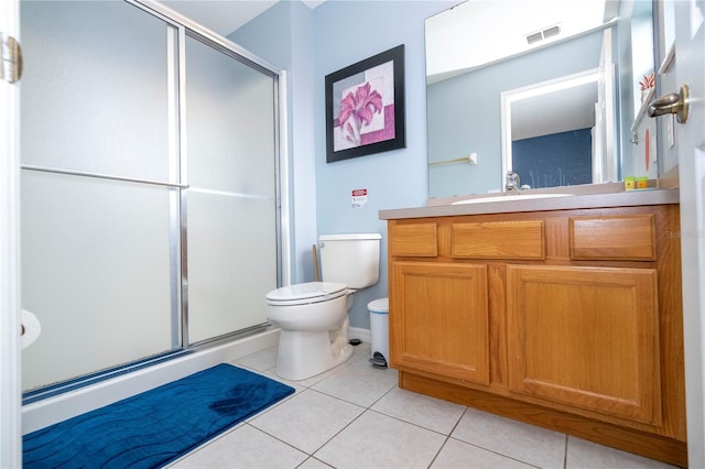 bathroom featuring vanity, walk in shower, toilet, and tile patterned flooring