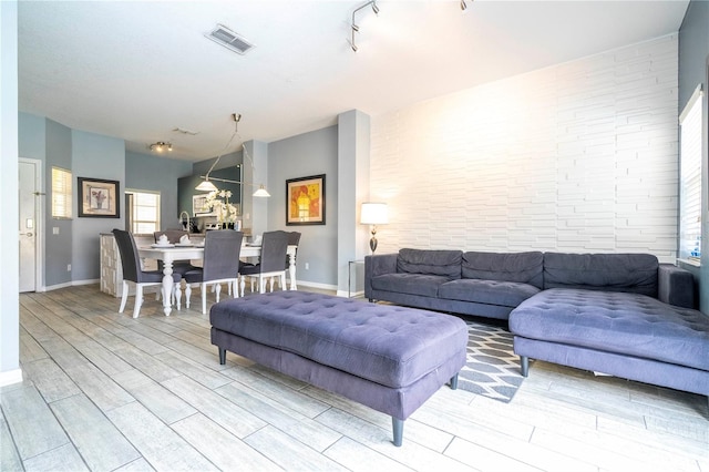 living room featuring track lighting and light hardwood / wood-style flooring