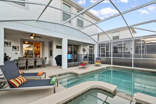 view of pool with a jacuzzi, a patio, ceiling fan, and glass enclosure