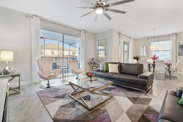 tiled living room with a wealth of natural light and ceiling fan