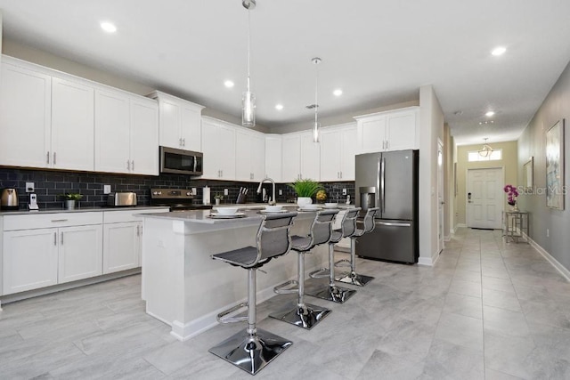 1585 Mulligan Blvd, Davenport, FL 33896 - kitchen featuring stainless steel appliances, decorative backsplash, recessed lighting, a kitchen island with sink, and a breakfast bar area