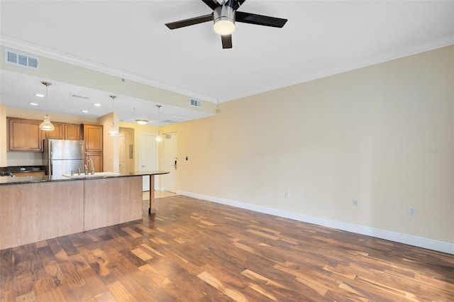 kitchen featuring crown molding, dark hardwood / wood-style flooring, ceiling fan, and stainless steel refrigerator