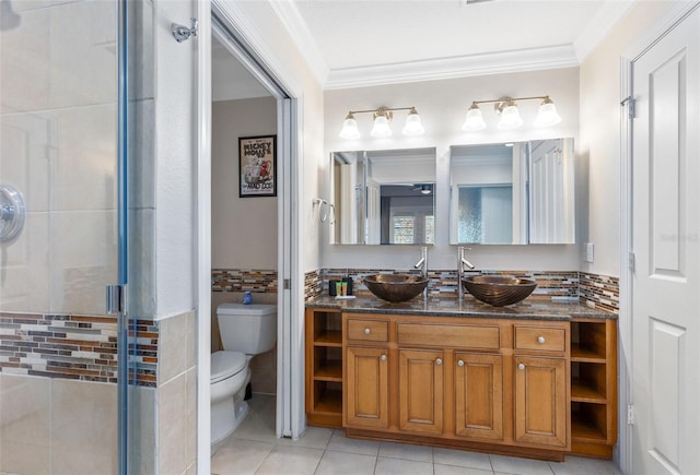 bathroom featuring tile patterned floors, toilet, a shower with shower door, vanity, and ornamental molding